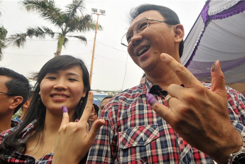 Calon Wakil Gubernur DKI Jakarta, Basuki Tjahaja Purnama atau Ahok (kanan), bersama istrinya Veronica (kiri) menunjukkan jari mereka yang telah diberi tanda tinta usai memberikan hak suaranya di Tempat Pemungutan Suara (TPS) 059 Kelurahan Pluit, Penjaringa