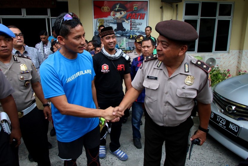 Calon Wakil Gubernur DKI Jakarta nomor urut tiga, Sandiaga Uno (kiri) meninggalkan kantor polisi usai menjalani pemeriksaan di Polsek Tanah Abang, Jakarta, Jumat (17/3). 