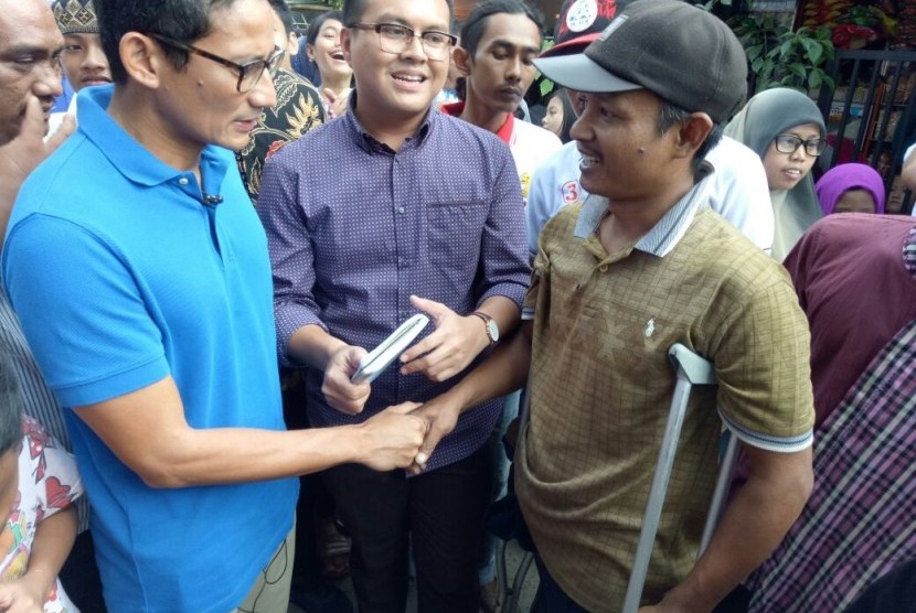 Calon Wakil Gubernur DKI Jakarta, Sandiaga Salahuddin Uno, mendengarkan keluhan seorang warga penyandang difabel, Heryanto, di Jalan Swadaya RW07, Jatinegara, Jakarta Timur, Sabtu (4/2). 