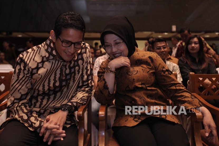 Calon wakil gubernur Sandiaga Uno (kiri) berbincang bersama calon wakil gubernur Sylviana Murni (kanan) saat menghadiri penganugerahan MH Thamrin yang diselenggarakan di Balai Kota, Jakarta, Senin (26/9).