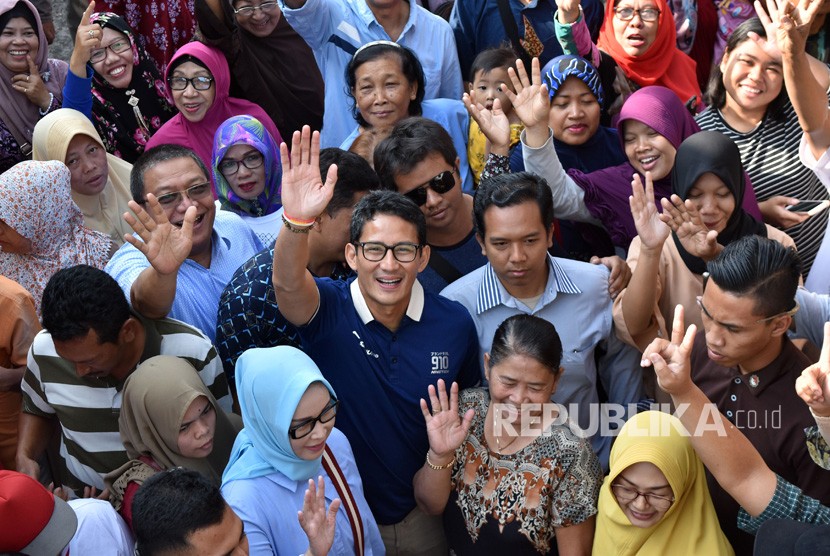 Calon Wakil Presiden nomer urut 02 Sandiaga Salahudin Uno (tengah) berfoto bersama warga saat berkampanye di Pasar Harjosari, Bawen, Kabupaten Semarang, Rabu (24/10/2018).