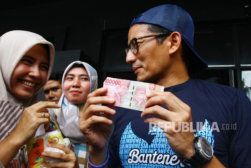 Calon Wakil Presiden nomer urut 02 Sandiaga Uno (kanan) menerima titipan uang sebesar Rp. 100ribu untuk dana kampanye dari seorang warga seusai melakukan diskusi Ruang Sandi di Tangerang, Banten, Selasa (15/1/2019). 