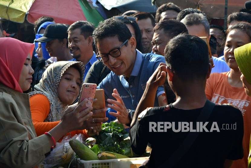 Calon Wakil Presiden nomor urut 02 Sandiaga Salahuddin Uno (tengah) melayani warga yang ingin berfoto bersamanya, saat berkunjung di Pasar Wonodri Semarang, Jawa Tengah, Senin (24/9). 