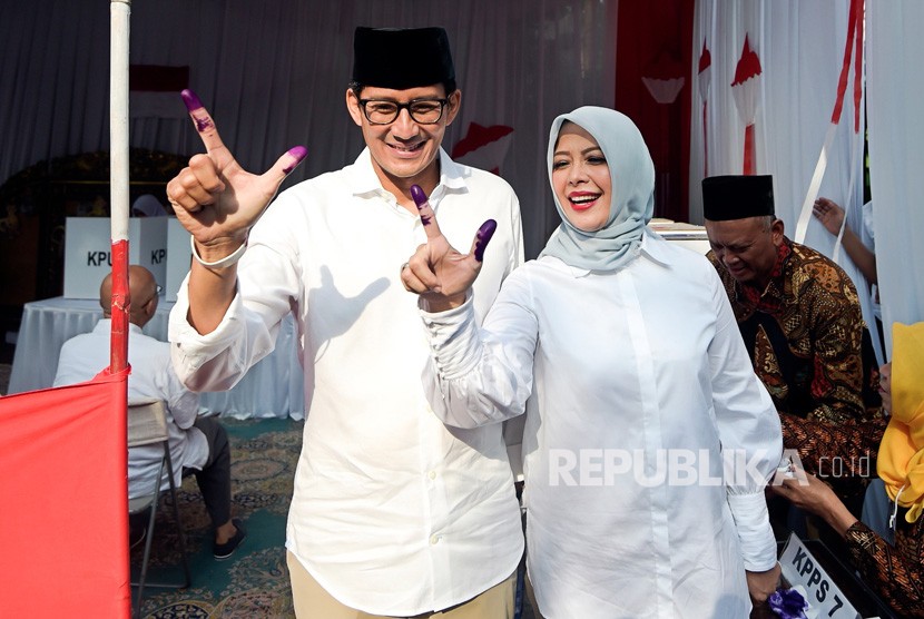 Calon Wakil Presiden nomor urut 02 Sandiaga Uno (kiri) dan istri Nur Asia Uno (kanan menunjukkan jari yang telah dicelup tinta usai melakukan pencoblosan dalam Pemilu 2019 di TPS 02, Jakarta, Rabu (17/4/2019).