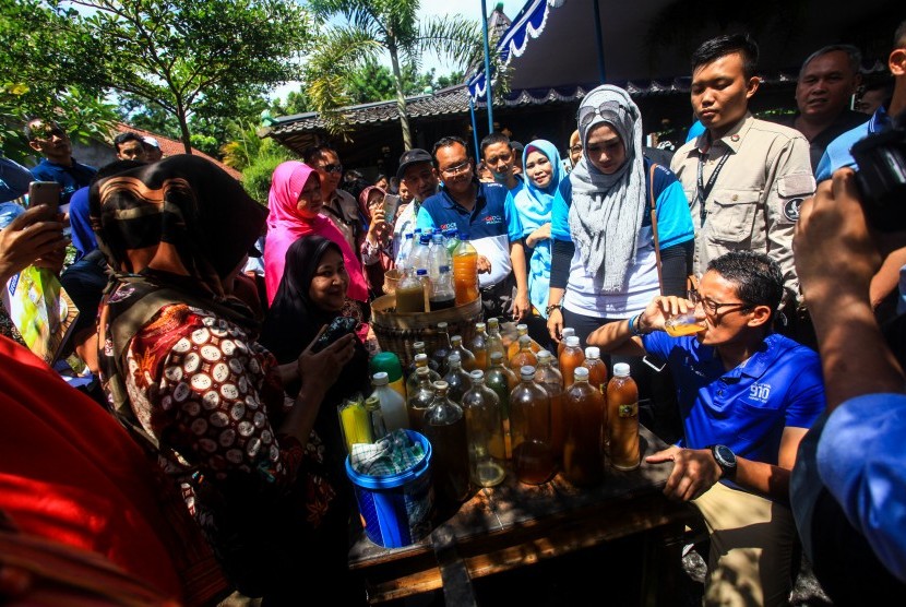 Calon Wakil Presiden nomor urut dua, Sandiaga Uno (kanan) mencicipi jamu olahan UMKM saat melakukan safari politik di Cengkir Heritage Resto & Cafe, Sleman, DI Yogyakarta, Sabtu (23/3/2019).