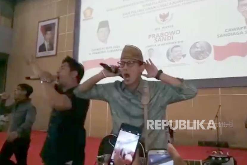 Calon Wakil Presiden Sandiaga Solahudin Uno turut berdendang menyanyikan lagu #2019PrabowoSandi ciptaan Sang Alang, di Gedung Smesco, Jakarta Selatan, Ahad (23/9).