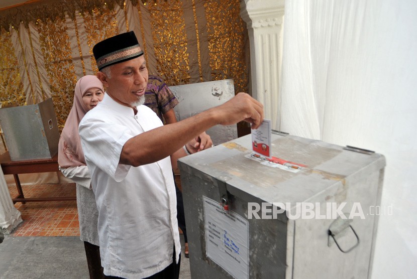 Calon Wali Kota Padang, Mahyeldi bersama istri, menggunakan hak pilih di TPS 7, Parupuk Tabing, Padang, Sumatera Barat, Rabu (27/6).