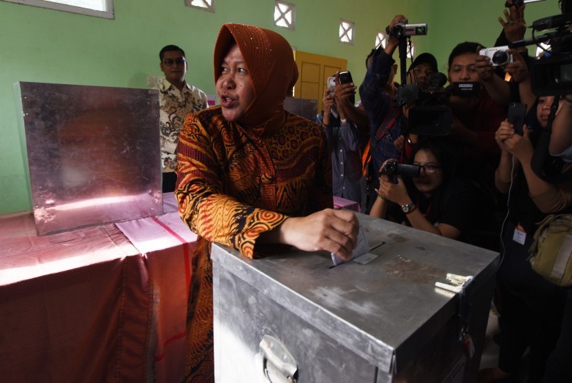 Calon Wali Kota Surabaya Tri Rismaharini memasukkan kertas surat ke kotak suara di TPS 01 Wiyung, Surabaya, Jawa Timur, Rabu (9/12). 