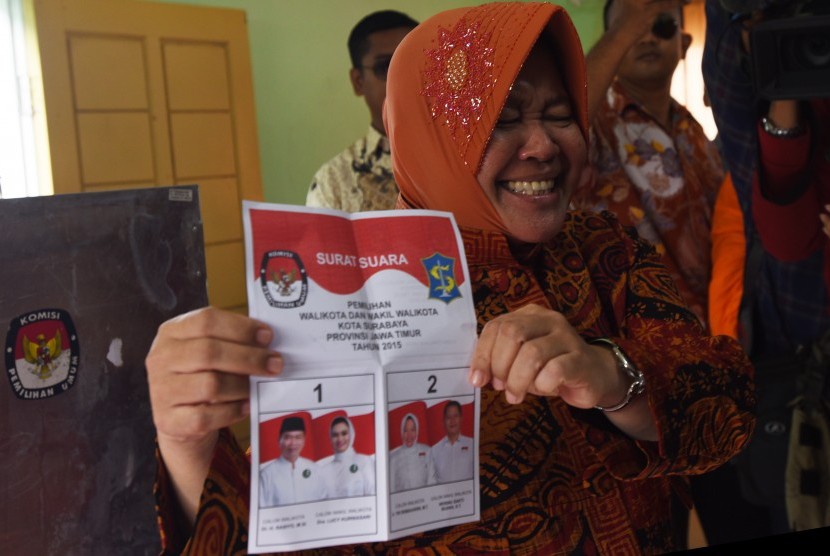 Calon Wali Kota Surabaya Tri Rismaharini memperlihatkan kertas surat di TPS 01 Wiyung, Surabaya, Jawa Timur, Rabu (9/12). 