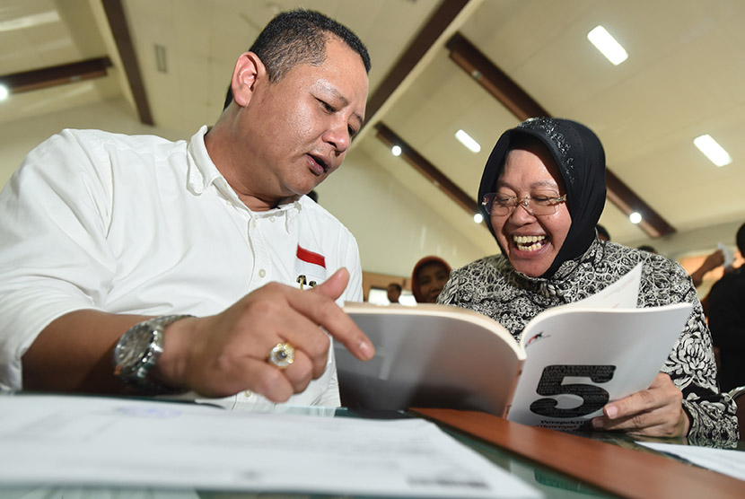 Calon Walikota Surabaya Tri Rismaharini (kanan) dan pasangannya calon Wakil Walikota Surabaya Wisnu Sakti Buana (kiri) membaca buku yang dibagikan KPK ketika mengikuti pembekalan dan deklarasi calon kepala daerah dan penyelenggara Pilkada Jatim di Unesa, S