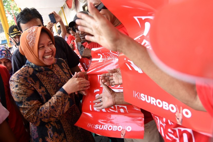 Calon Walikota Surabaya, Tri Rismaharini (kiri) berjabat tangan dengan warga disela-sela peresmian posko pemenangan Risma-Wisnu di Surabaya, Jawa Timur, Senin (2/11). 