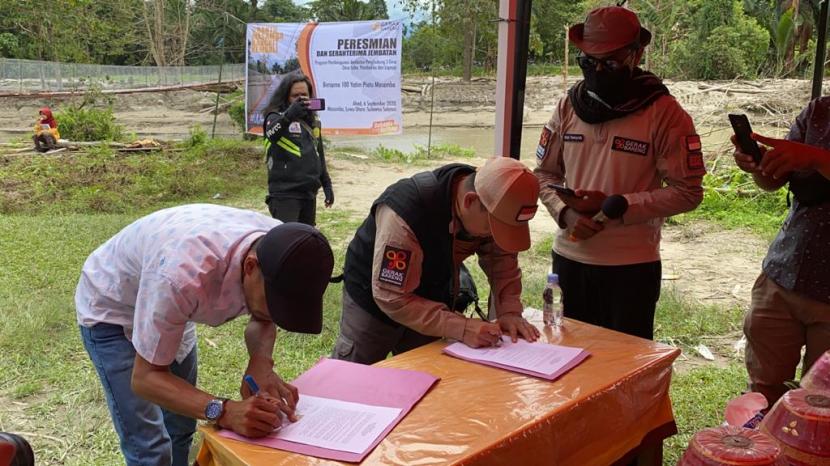 Camat Masamba, Ajie Saputra; dan perwakilan pimpinan Gerak Bareng menandatangani peresmian Jembatan Putih di Kecamatan Masamba, Kabpaten Luwu utara, Provinsi Sulawesi Selatan, Ahad (6/9).