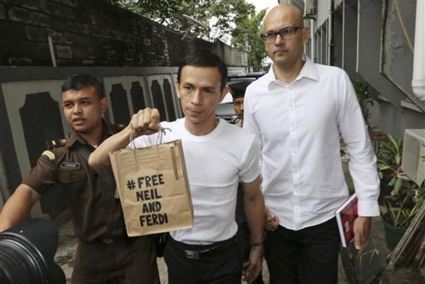 Canadian teacher Neil Bantleman, right, walks with Indonesian teaching assistant, Ferdinant Tjiong prior to the start of their trial hearing at South Jakarta District Court in Jakarta, Indonesia, Tuesday, Dec. 2, 2014.