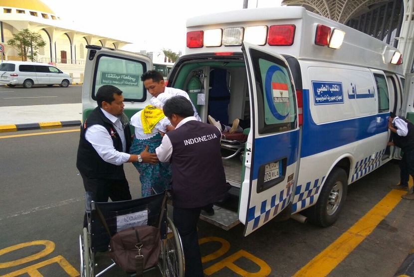 Caon jamaah haji yang sakit dibawa ke kendaraan ambulan.