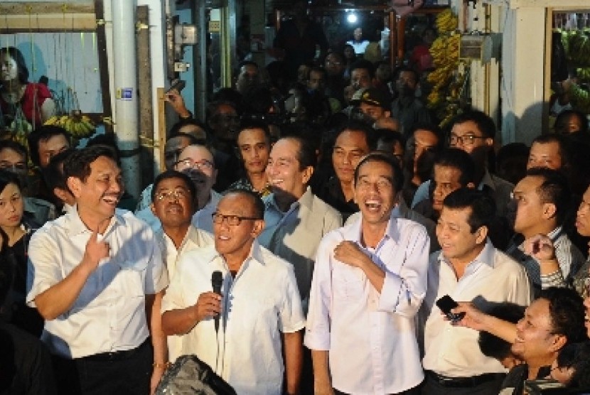 Capres dari PDIP Joko Widodo (tengah) dengan Ketua Umum DPP Partai Golkar Aburizal Bakrie (kiri).berdampingan saat mengunjungi pasar Gembrong di Cempaka Putih, Jakarta, Selasa (13/5).