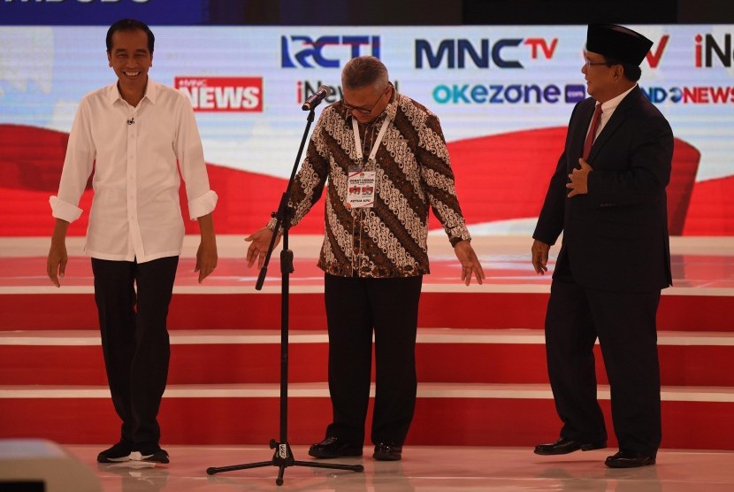Capres nomor urut 01 Joko Widodo (kiri) dan Capres nomor urut 02 Prabowo Subianto (kanan) bersiap memulai debat capres 2019 disaksikan Ketua KPU Arief Budiman (tengah) di Hotel Sultan, Jakarta, Ahad (17/2/2019).