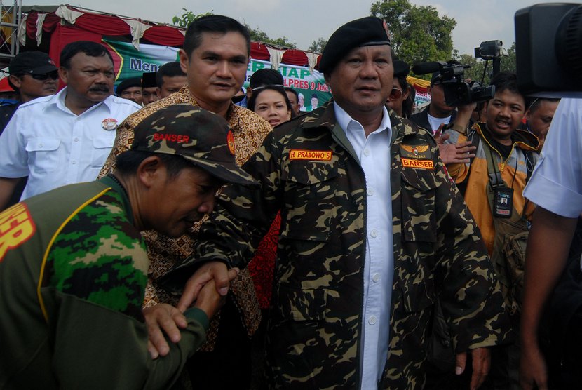  Capres nomor urut satu,  Prabowo Subianto (dua kanan) memakai jaket dan baret Banser usai memimpin Apel Banser untuk Indonesia bangkit di Lapangan Puri, Mojokerto, Jawa Timur, Selasa (24/6).  (Antara/Syaiful Arif)