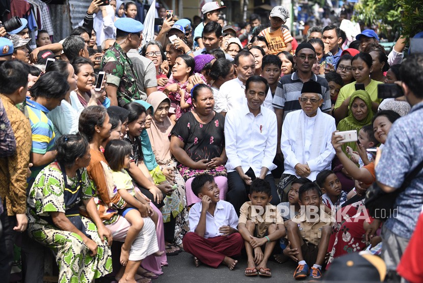 Capres petahana Joko Widodo dan cawapres Ma'ruf Amin menyapa warga usai menyampaikan pidato kemenangannya sebagai Presiden Republik Indonesia periode 2019-2024 di Kampung Deret, Tanah Tinggi, Johar Baru, Jakarta Pusat, Selasa (21/5/2019). 