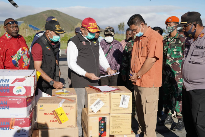 Direktur Perlindungan Sosial Korban Bencana Alam M Safii Nasution topi merah membawa bantuan kemensos senilai 300 jt bagi warga Paniai terdampak banjir bandang. safii juga berdialog dengan kepala suku Paniai Alfon Sadi (nunjuk) mengenai kebutuhan pengungsi di  Balai Desa Uwibutu, Paniai, Papua, hari ini. 