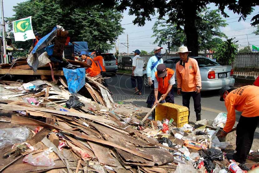 Sejumlah petugas kebersihan membersihkan sampah yang berserakan di pinggir Jalan I Gusti Ngurah Rai, Klender, Jakarta Timur, Selasa (4/3). (foto : Raisan Al Farisi)