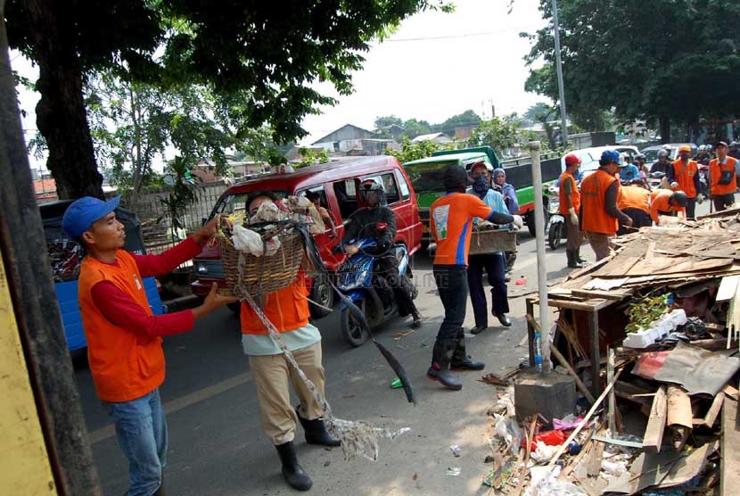  Sejumlah petugas kebersihan membersihkan sampah yang berserakan di pinggir Jalan I Gusti Ngurah Rai, Klender, Jakarta Timur, Selasa (4/3). (foto : Raisan Al Farisi)