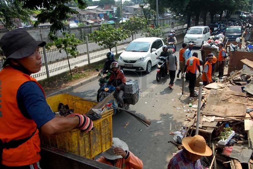  Sejumlah petugas kebersihan membersihkan sampah yang berserakan di pinggir Jalan I Gusti Ngurah Rai, Klender, Jakarta Timur, Selasa (4/3). (foto : Raisan Al Farisi)