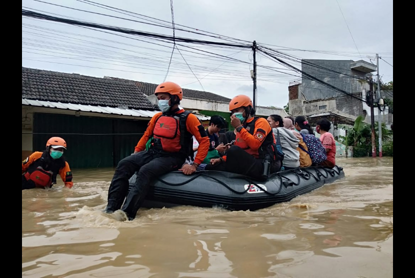 Sejumlah relawan DD, mengevakuasi  warga menuju tempat yang aman dari kepungan banjir di Cipinang Melayu, Jakarta Timur, Jumat, (19/02). 