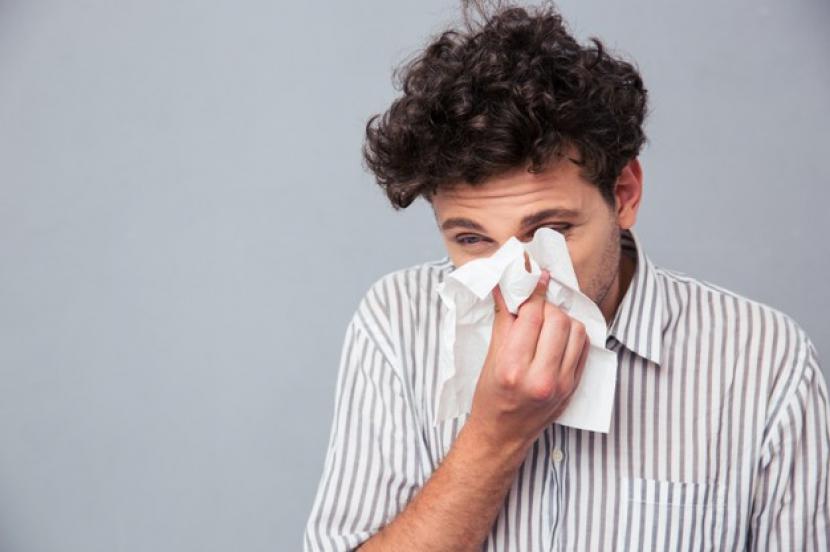 Seorang pria sedang menyeka hidungnya saat flu. Orang bisa kena Covid-19 tanpa menyadarinya. (ilustrasi).