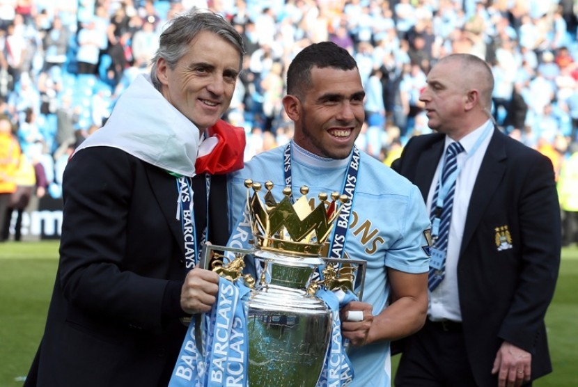 Carlos Tevez dan Roberto Mancini merayakan gelar liga Primer Inggris. Tevez dikabarkan salah satu pemain yang akan dijual City musim depan