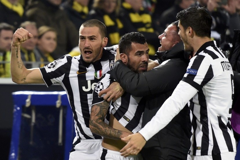 Carlos Tevez of Juventus (C) celebrates his goal against Borussia Dortmund with team mates Leonardo Bonucci (R) and Alvaro Morata (R) during their Champions League round of 16 second leg soccer match in Dortmund March 18, 2015. 