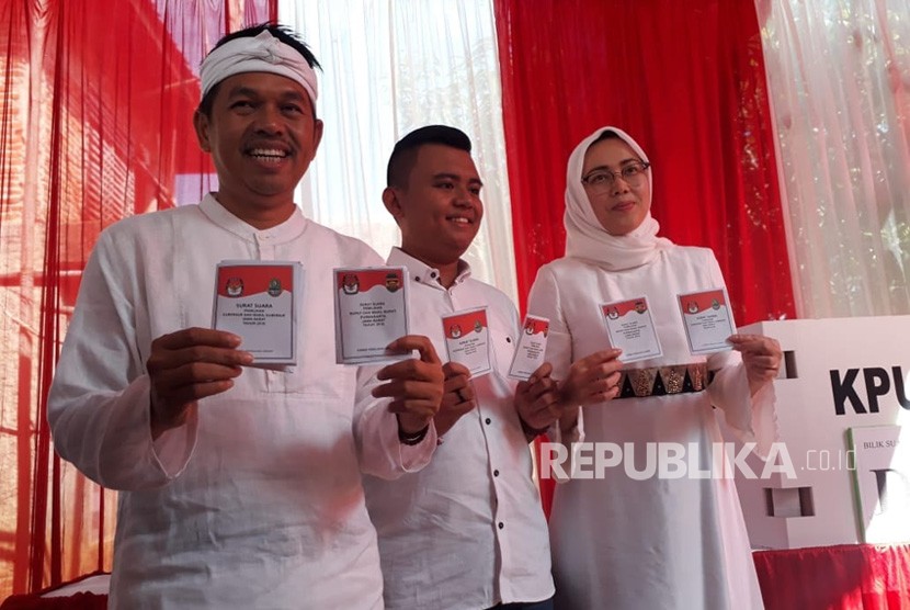 Cawagub Dedi Mulyadi didampingi isteri yang juga Cabup Purwakarta Anne Ratna Mustika, menunjukan surat suara di TPS 6, Kampung Krajan, Desa Sawahkulon, Kecamatan Pasawahan, Rabu (27/6). 