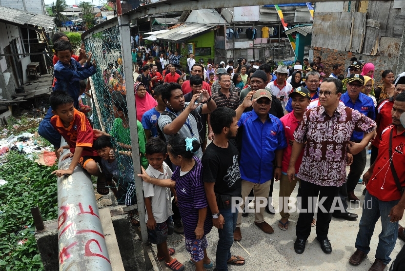 Cagub DKI Jakarta Anies Baswedan (kanan) berdialog dengan warga