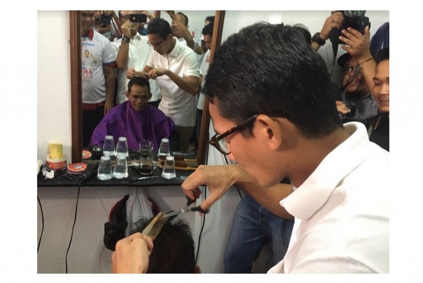 Cawagub DKI, Sandiaga Uno saat mencoba menjadi 'tukang cukur' kegiatan cukur rambut gratis di 100 titik di Jakarta.