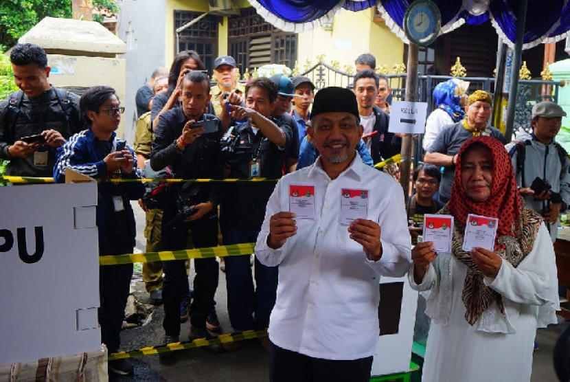 Cawagub Jabar Akhmad Syaikhu bersama istri menyoblos di TPS 76 Komplek Antara, Pondokgede, Kota Bekasi Rabu (27/6).