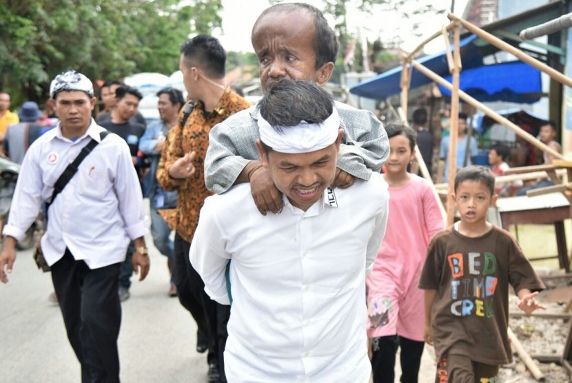 Cawagub Jabar Dedi Mulyadi menggendong seorang pengemis Dede (35 tahun) warga Desa Bojong Sari, Kecamatan Kedung Waringin, Kabupaten Bekasi, beberapa waktu lalu.