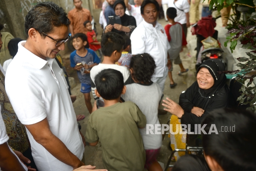 Cawagub nomer urut tiga Sandiaga S Uno menyapa warga sebelum melakukan sosialisasi warga di kawasan Kebon Melati, Tanah Abang, Jakarta Pusat, Senin (26/12). 