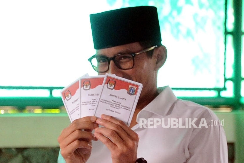 Cawagub Sandiaga Uno menunjukan surat suara saat akan pencoblosan di TPS 01 kawasan Senayan, Jakarta, Rabu (19/4).