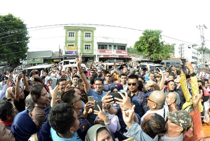 Cawapres nomor urut 02 Sandiaga Salahuddin Uno (tengah) berfoto bersama warga di Pasar Tugu, Bandar Lampung, Lampung, Selasa (9/10).