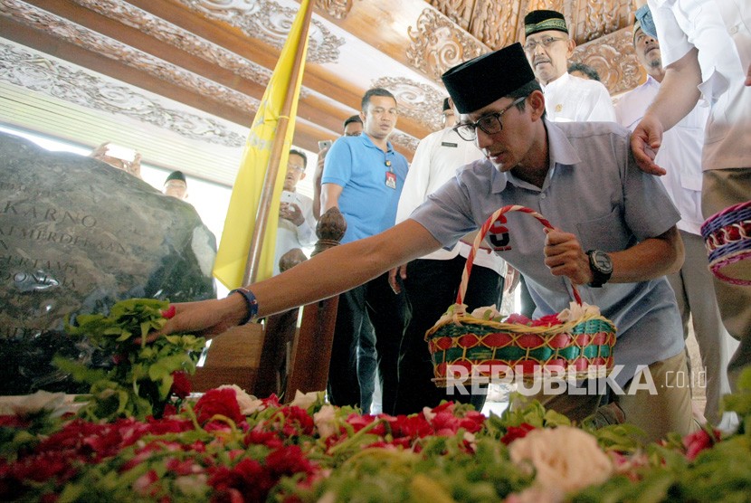 Cawapres Nomor urut 02 Sandiaga Salahudin Uno (kanan) menaburkan bunga di pusara makam Presiden Soekarno saat berziarah di Kota Blitar, Jawa Timur, Rabu (19/12/2018). 