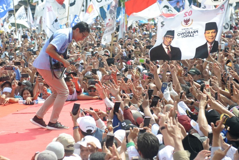 Cawapres nomor urut 02 Sandiaga Uno memainkan gitar saat menghadiri kampanye akbar di Lapangan Ahmad Yani, Alun - Alun Kota Tanggerang, Banten, Sabtu (13/4/2019). 