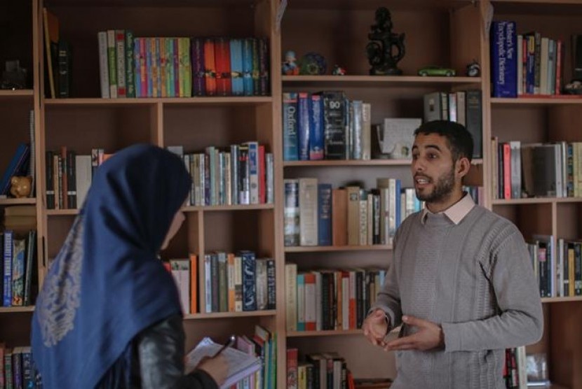 Cendekiawan Palestina, Abu Toha, membuka perpustakaan yang didominasi oleh koleksi buku sastra Inggris di apartemennya di Beit Lahla, Palestina.
