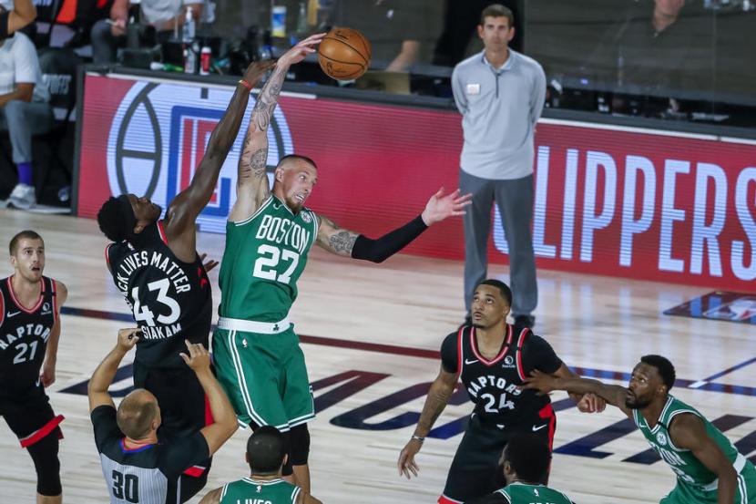 Center Boston Celtics Daniel Theis merebut bola jump ball dari forward Toronto Raptors Pascal Siakam dalam pertandingan keenam semifinal WIlayah Timur NBA, di ESPN Wide World of Sports Complex, Kissimmee, Florida, AS, Kamis (10/9). 