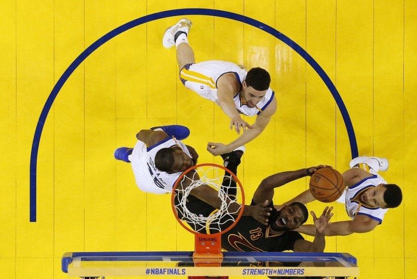 Center Cleveland Cavaliers Tristan Thompson hendak memasukkan bola, dijaga oleh tiga pemain Golden State Warriors pada gim kedua final NBA 2017.