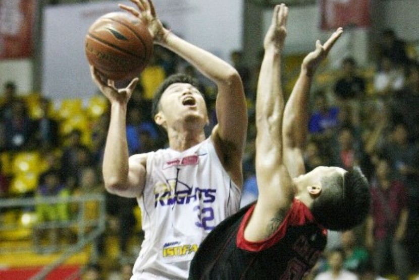 Center CLS Knights Herman (kiri) berusaha memasukkan bola dijaga oleh forward Garuda Christ Gideon dalam lanjutan NBL Indonesia Seri II Bandung, Sabtu (13/12).