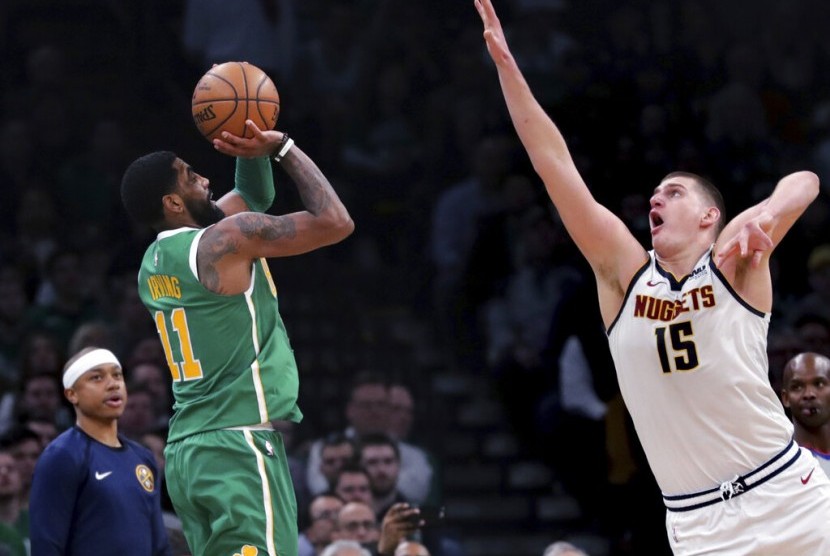 Center Denver Nuggets Nikola Jokic berusaha menghalangi guard Boston Celtics Kyrie Irving menembak.