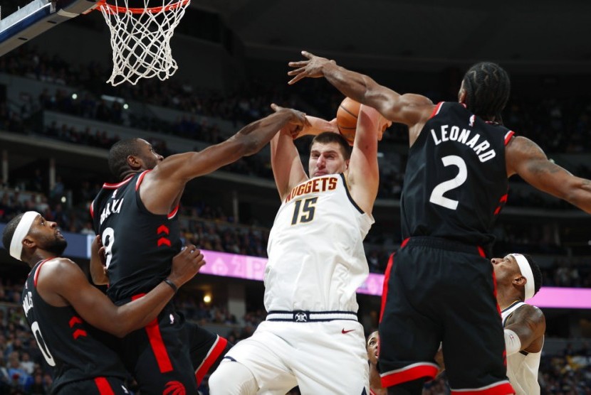 Center Denver Nuggets Nikola Jokic (putih) dijaga para pemain Toronto Raptors.