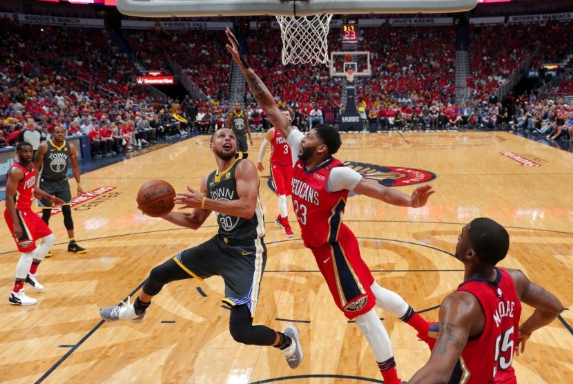 Center New Orleans Pelicans, Anthony Davis (tengah) mengadang guard Golden State Warriors, Stephen Curry (kiri) pada laga gim ketiga semifinal playoff wilayah Barat NBA, di Smoothie King Center, Sabtu (5/5) pagi WIB. Pelicans menang 119-100.