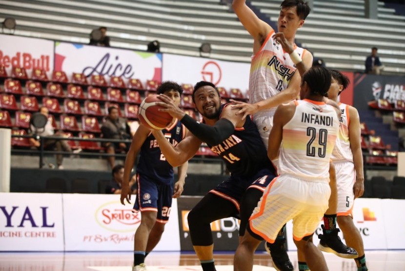 Center Pelita Jaya (PJ) Basketball Adhi Pratama berusaha memasukkan bola dijaga sejumlah pemain NSH Jakarta pada Piala Presiden Bolabasket 2019.