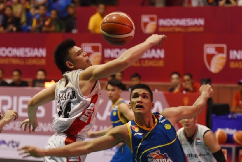 Center Satria Muda Pertamina Kevin Yonas (biru) berebut bola dengan center Aspac Ferdinand Damanik dalam pertandingan IBL di Jakarta, Sabtu (9/1).