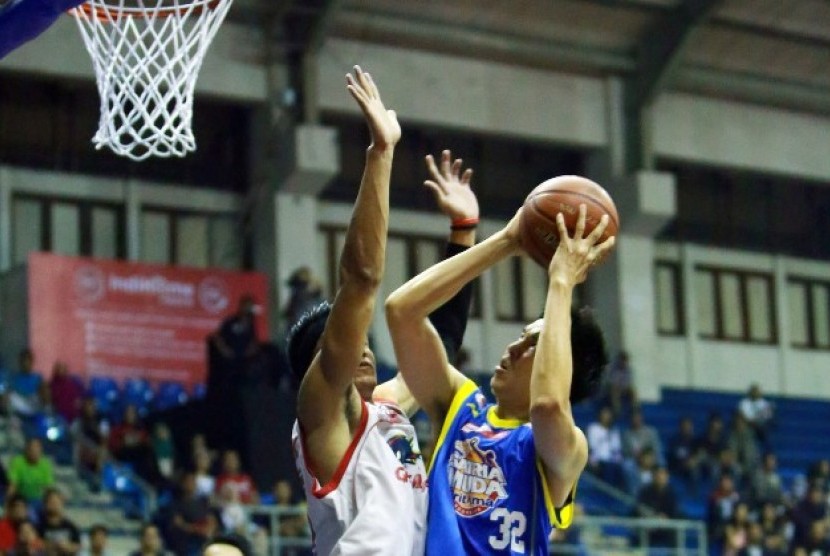 Center Satria Muda Rony Gunawan berusaha memasukkan bola.